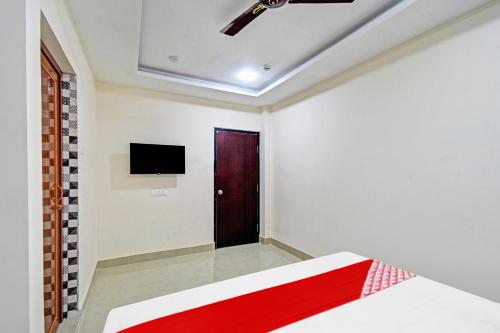 a bedroom with a bed and a door at Hotel O ASHIRBAD PALACE in Urāli
