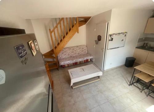 a small kitchen with a refrigerator and a staircase at Maison avec jardin in Calvisson