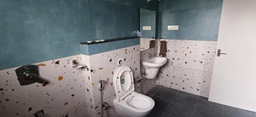 a dirty bathroom with a toilet and a sink at Belmonte in Kalasa