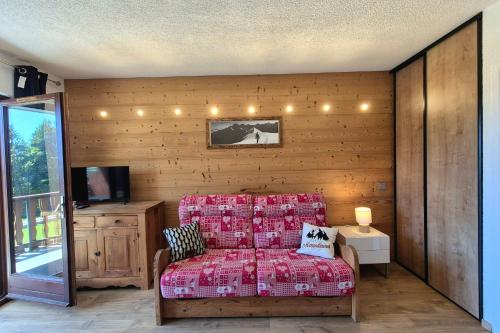 a room with a bed and a tv and a table at Chaleureux studio au pied des pistes - Le refuge in Les Déserts