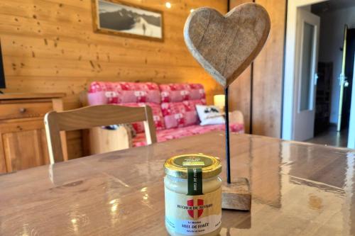 a wooden table with a heart in a living room at Chaleureux studio au pied des pistes - Le refuge in Les Déserts