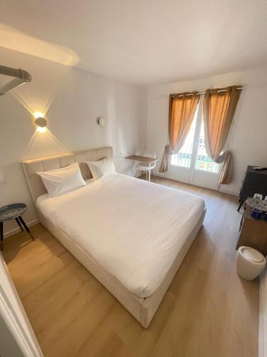 a bedroom with a large white bed and a window at Aparthotel New Palmarium in Amélie-les-Bains-Palalda
