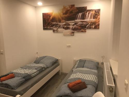 two twin beds in a room with paintings on the wall at Haus Jörg in Lutter