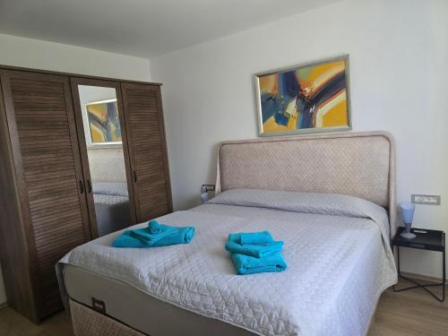 a bedroom with a bed with two blue towels on it at Apartment Maja in Labin