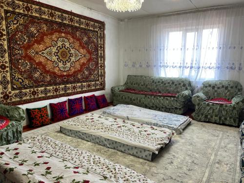 a living room with two beds and a rug at Sunrise Panorama in Bokonbayevo