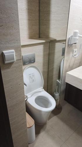 a bathroom with a white toilet and a sink at Ruby Apartment #34 in Yogyakarta