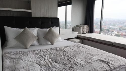 a bedroom with a large bed with a large window at Ruby Apartment #34 in Yogyakarta