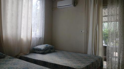 a bedroom with a bed and a window with curtains at Erdek Özlem pansiyon in Erdek