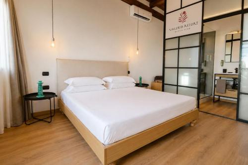 a bedroom with a large bed with white sheets and pillows at Valerio Resort beach club in Margherita di Savoia