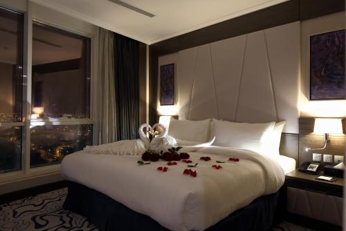 a hotel room with two swans and flowers on a bed at Swiss Flora Royal Hotel Riyadh in Riyadh