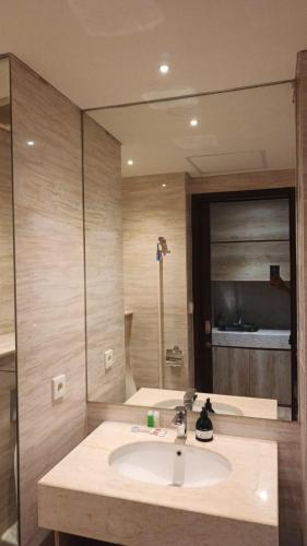 a bathroom with a sink and a large mirror at Ruby Apartment #47 in Kejayan