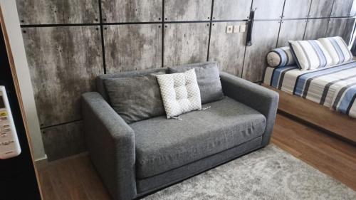 a living room with a couch and a bed at Ruby Apartment #47 in Kejayan