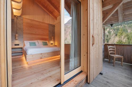 a bedroom in a wooden cabin with a bed and a window at Agriturismo La Daga Nature Lodge in Auronzo di Cadore