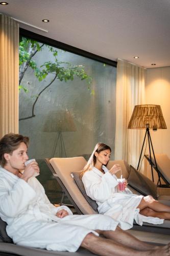 a group of people in white robes sitting on a couch at Hotel Seehof Nature Retreat in Natz-Schabs