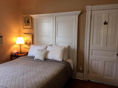 een slaapkamer met een bed met witte kussens bij Ellis House Bed & Breakfast in Niagara Falls