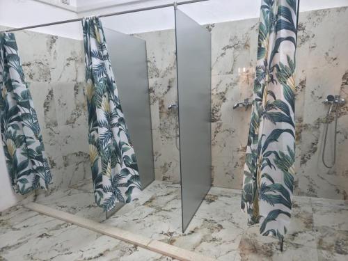 a bathroom with a shower and a mirror at City Center Hostel Durres in Durrës