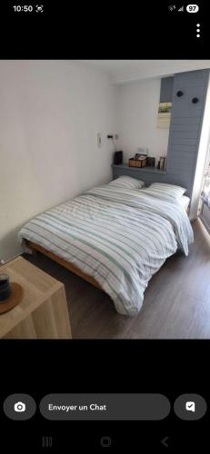 a bedroom with a bed with a striped blanket at L'aube de Vouglans 5 kms des plages in Pont-de-Poitte