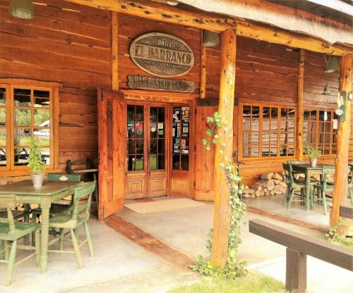 a restaurant with tables and chairs in front of a building at Hotel El Barranco in Futaleufú