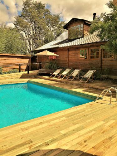 a swimming pool in front of a house at Hotel El Barranco in Futaleufú