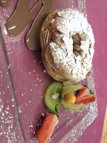a bagel with powdered sugar and fruit on a table at Relais du Klevener in Heiligenstein