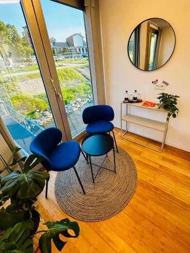 a room with two blue chairs and a mirror at Sundeck botel - party boat in Bratislava