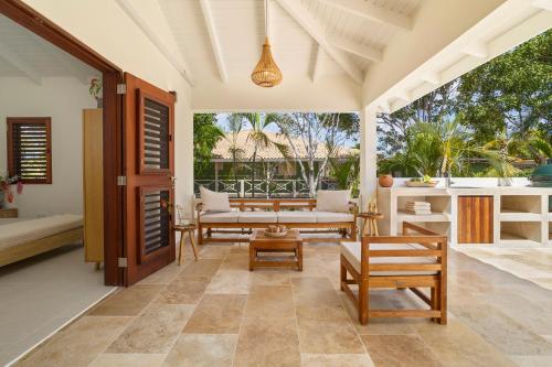 a patio with a couch and a table and chairs at Casa del Viento Private Pool Villa near Kitesurf Beach and Sorobon in Kralendijk