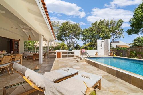 an outdoor patio with a swimming pool and a villa at Casa del Viento Private Pool Villa near Kitesurf Beach and Sorobon in Kralendijk