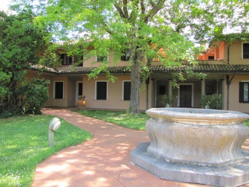 a large stone fountain in front of a building at Villa G in Ravenna