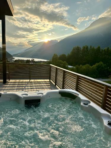 a hot tub on a deck with the sunset in the background at Loen Panorama in Stryn