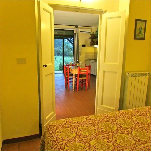 a bedroom with a bed and a kitchen with a table at Agriturismo "Borgo Madonna degli Angeli" - charming cottages in the gardens ! in Tocco da Casauria
