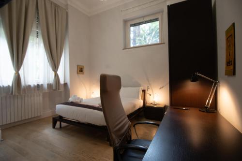 a bedroom with a bed and a desk with a chair at Superior Room - Smart Working - 100m from center in Salerno