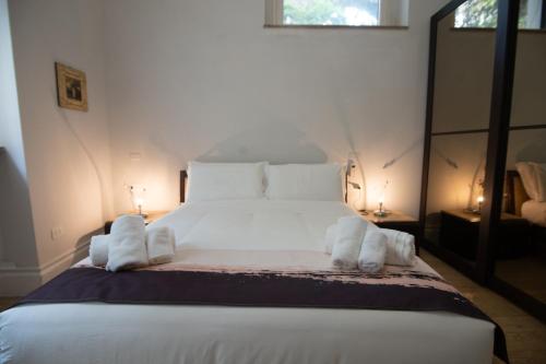 a bedroom with a large white bed with towels on it at Superior Room - Smart Working - 100m from center in Salerno