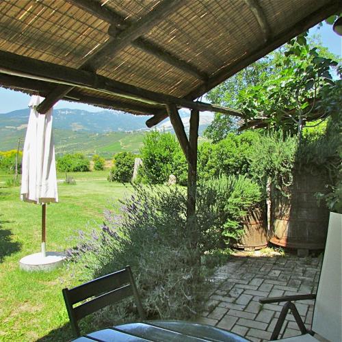 a patio with a table and chairs under a pergola at Agriturismo "Borgo Madonna degli Angeli" - charming cottages in the gardens ! in Tocco da Casauria