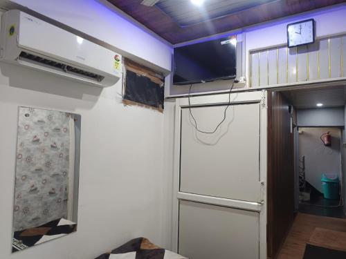 a small room with a kitchen and a refrigerator at RADHA Homestay in Mathura