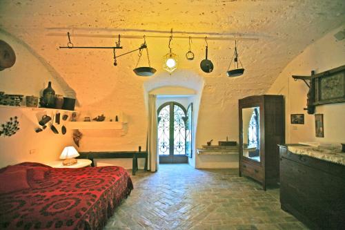 a bedroom with a bed and a table in a room at Agriturismo "Borgo Madonna degli Angeli" - charming cottages in the gardens ! in Tocco da Casauria