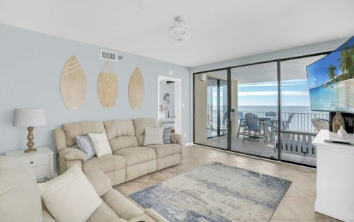 a living room with a large couch and a balcony at Corner on Romar 706 in Orange Beach