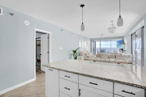 a kitchen with white cabinets and a view of the ocean at Corner on Romar 706 in Orange Beach