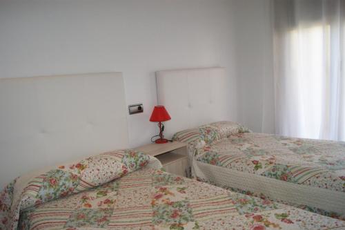 アルコセブレにあるAlcocebre Beach Resortのベッドルーム1室(ベッド2台、ランプ付きテーブル付)