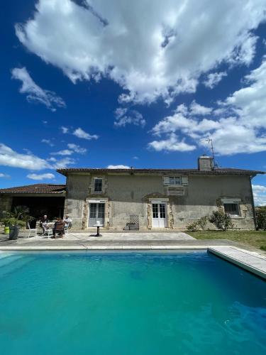 a house with a swimming pool in front of a house at Du coté de chez Flo in Bazas