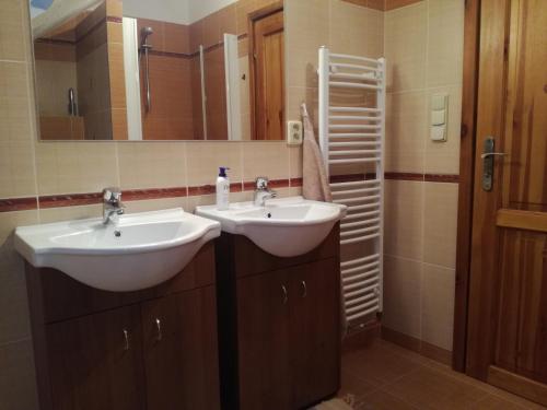 a bathroom with two sinks and a mirror at Apartmán u Kovářů in Kašperské Hory