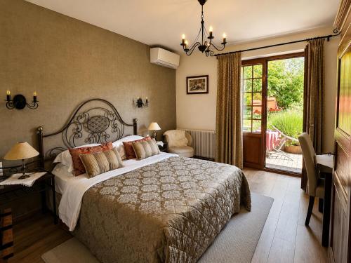 a bedroom with a large bed and a balcony at Maison Kieffer - Hotel & Vins d'Alsace in Itterswiller