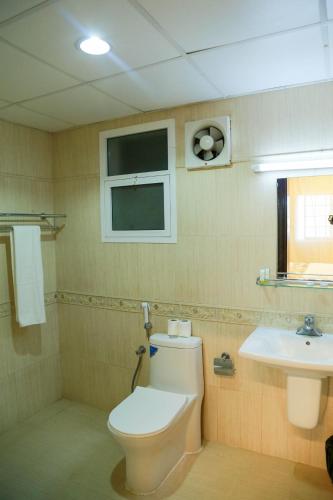 a bathroom with a toilet and a sink at Al Sahwa Residency in Ţāqah