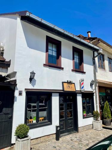 a white building with black doors and windows at Stari grad 1 in Valjevo