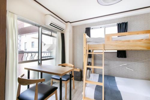 a small room with a desk and bunk beds at 第2舞鶴ハイツ in Fukuoka