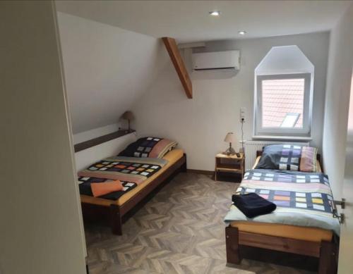 a bedroom with two beds and a window at Ferienapartment Meiss in Erdeborn