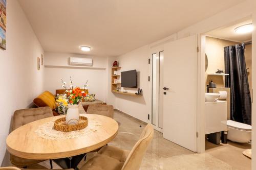 a living room with a dining room table and a kitchen at Apartmani Žunić in Pag