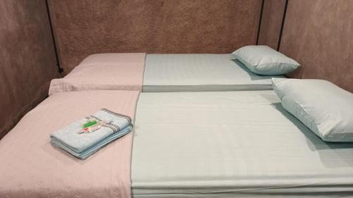 two twin beds with pink and white sheets and pillows at Omah Masayu in Yogyakarta