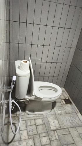 a bathroom with a toilet in a tiled room at Omah Masayu in Yogyakarta