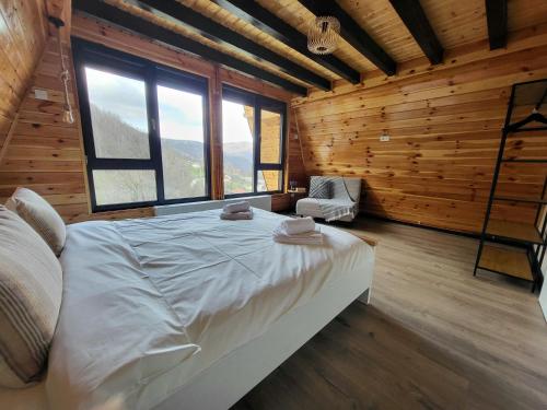 a bedroom with a large bed in a room with wooden walls at Hill House Doftana in Seciuri