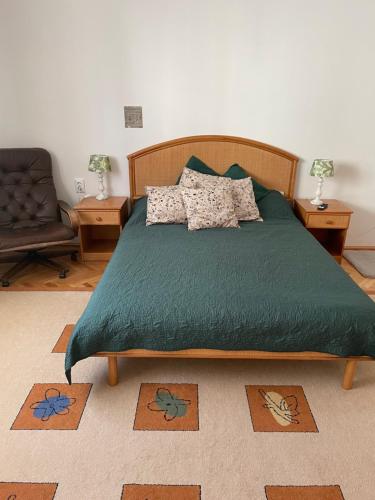 a bedroom with a bed with a green comforter at Viktória central apartman in Odorheiu Secuiesc